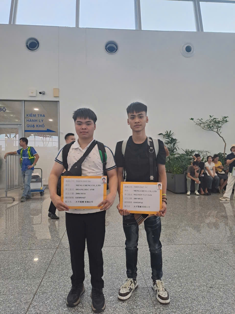 Hai lao động Việt Nam làm thủ tục xuất cảnh sang Đài Loan làm việc.