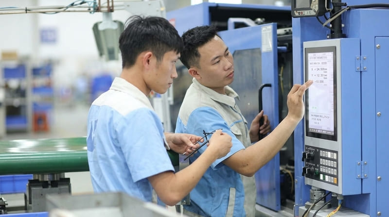 Nhân viên vận hành máy gia công CNC hiện đại tại xưởng cơ khí Đài Loan.